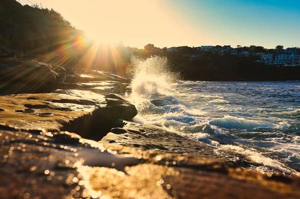 Waves breaking on rocks at golden hour